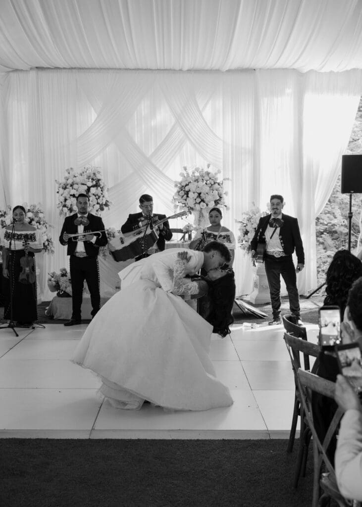 couple kissing and dipping at reception at Hidden Stone Palace under the tent