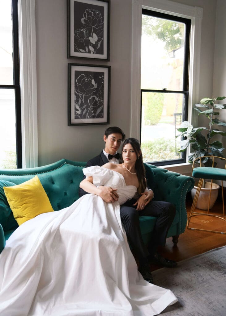 couple lounging on green sofa at Orting Manor posing for bridal photos