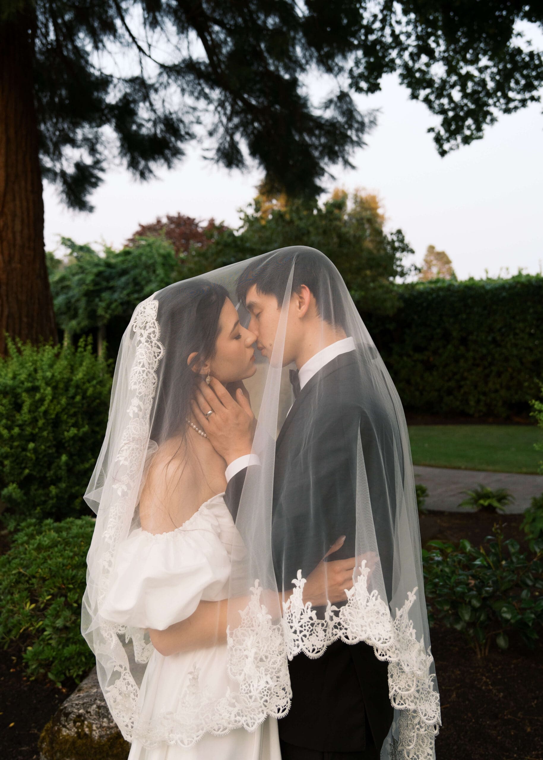 bride and groom under the veil almost kissing at sunset at Orting Manor