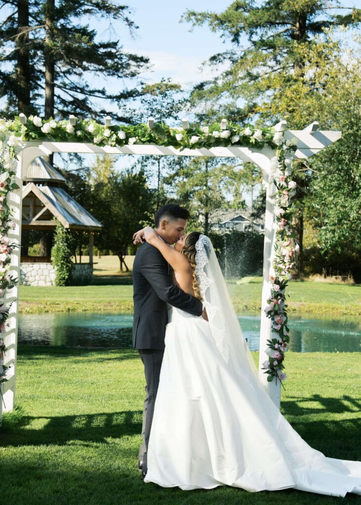 bride and groom's first kiss at outdoor ceremony at Vickery Gardens 
