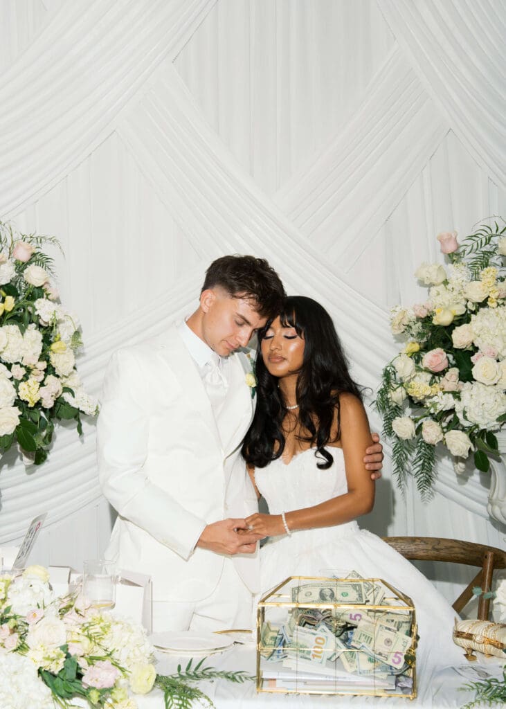married couple in white holding hands and leaning together in prayer at Tacoma wedding venue