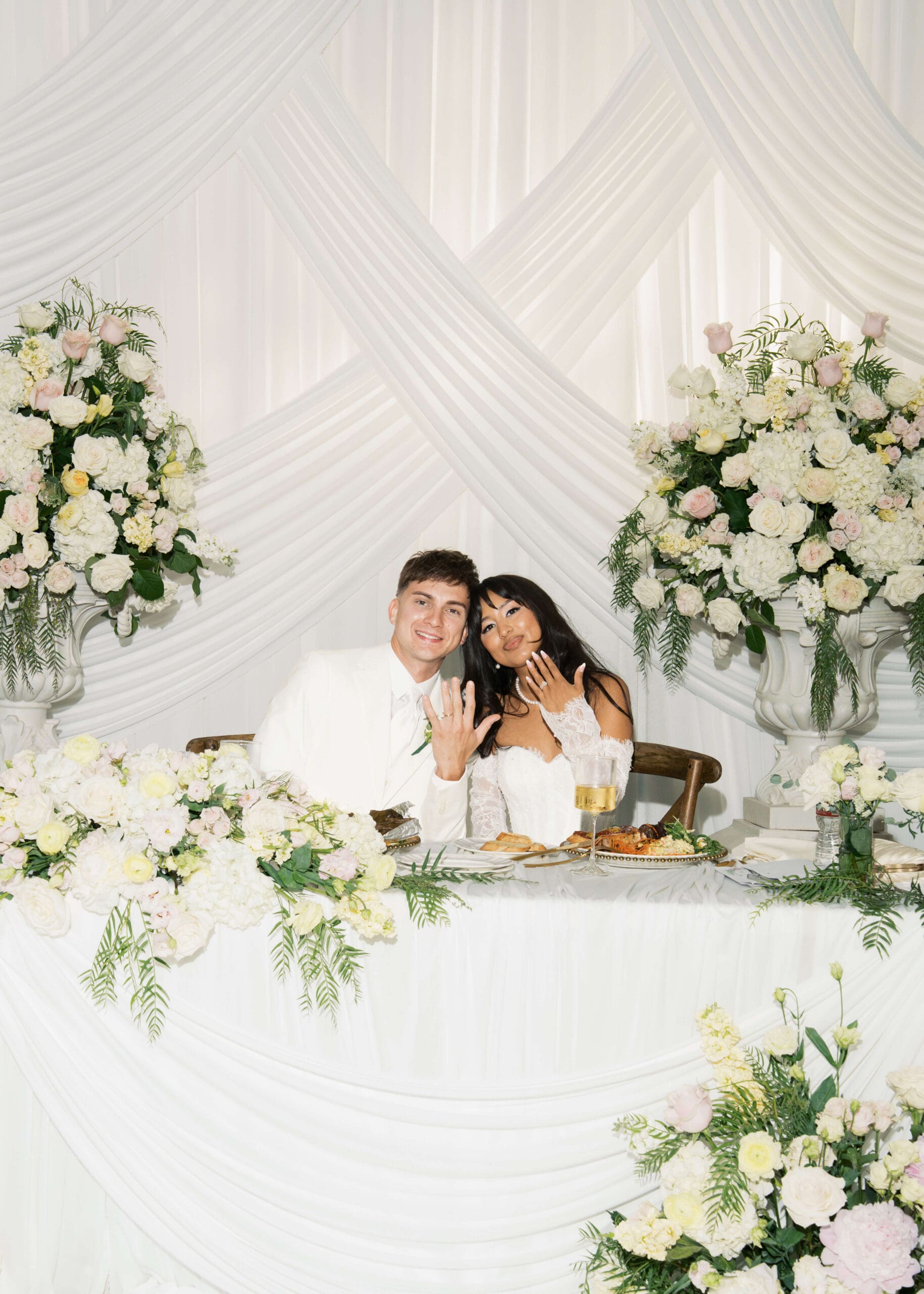 married couple in white showing off their wedding rings at Atelier Tacoma
