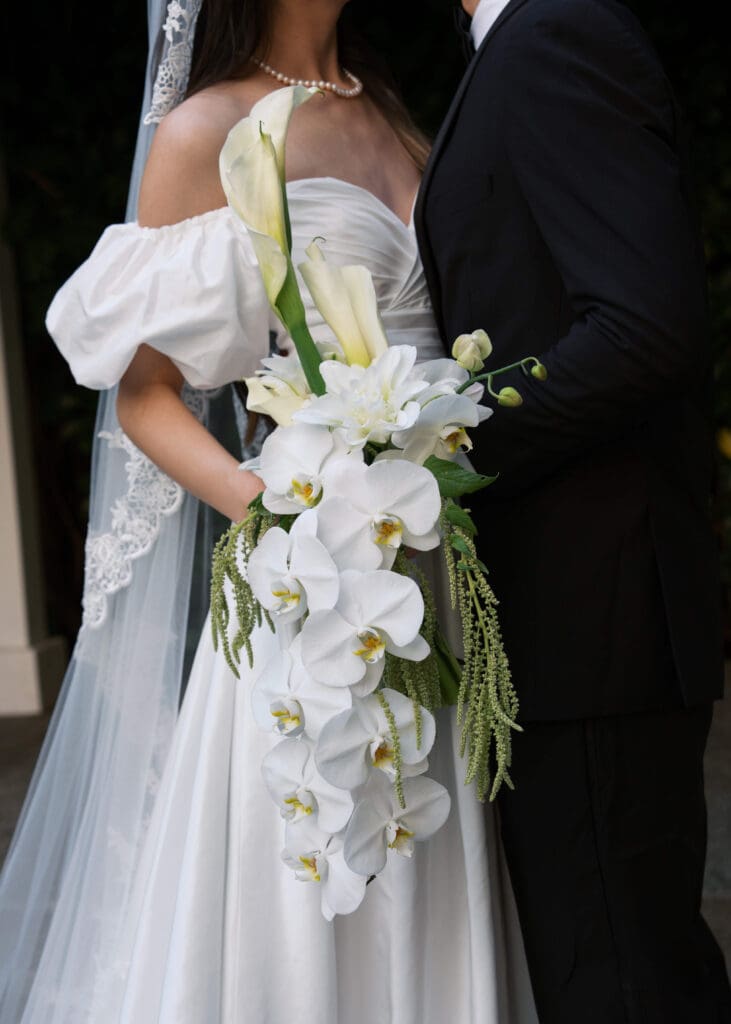 bride holding white and green bouquet with lillies