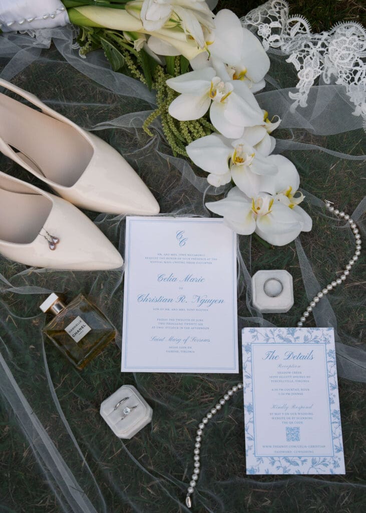 flat lay with veil, invitation, heels, jewelry, perfume, bouquet