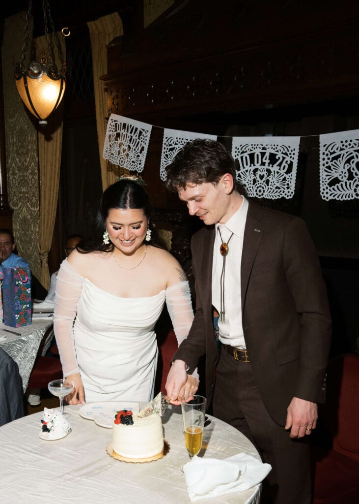 bride and groom cutting their cake at the wedding reception at Stimson-Green Mansion