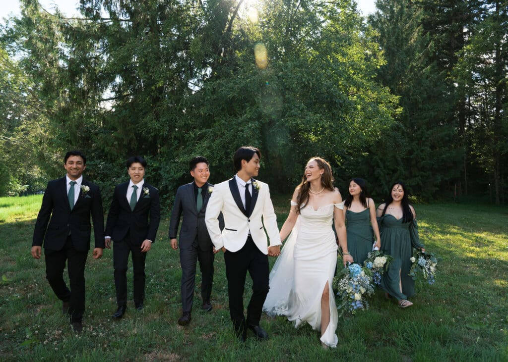 bride and groom holding hands and walking with their wedding party at The Lodge at Trinity Tree Farm