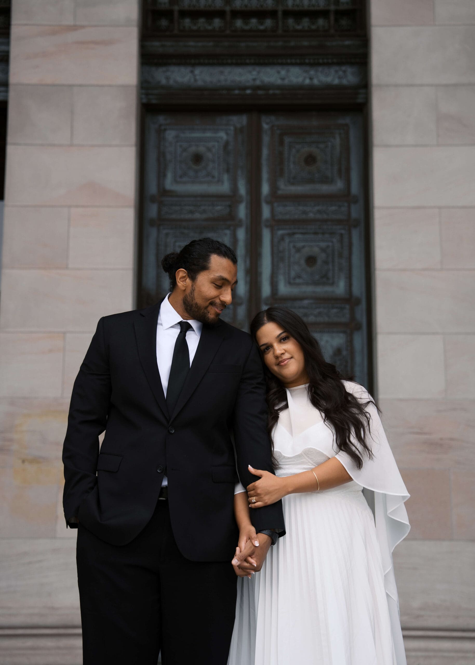 bride leaning on groom's shoulder in front of Washington State Capitol