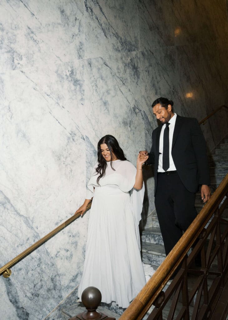bride and groom walking down the stairs and holding hands at Washington State Capitol wedding